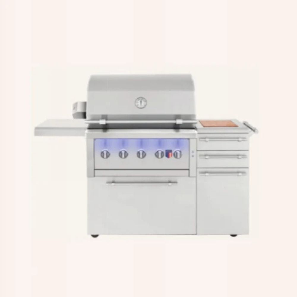 A stainless steel outdoor kitchen grill and side unit with a covered grill top, side deck table, drawers, and control knobs, shown on a plain light beige background.