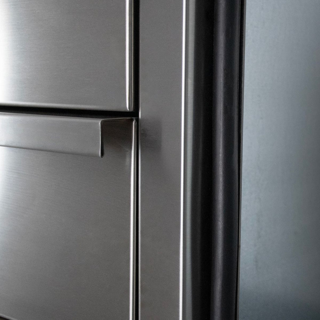 Close-up of a brushed stainless steel refrigerator door with a horizontal handle and dark trim along the edge.