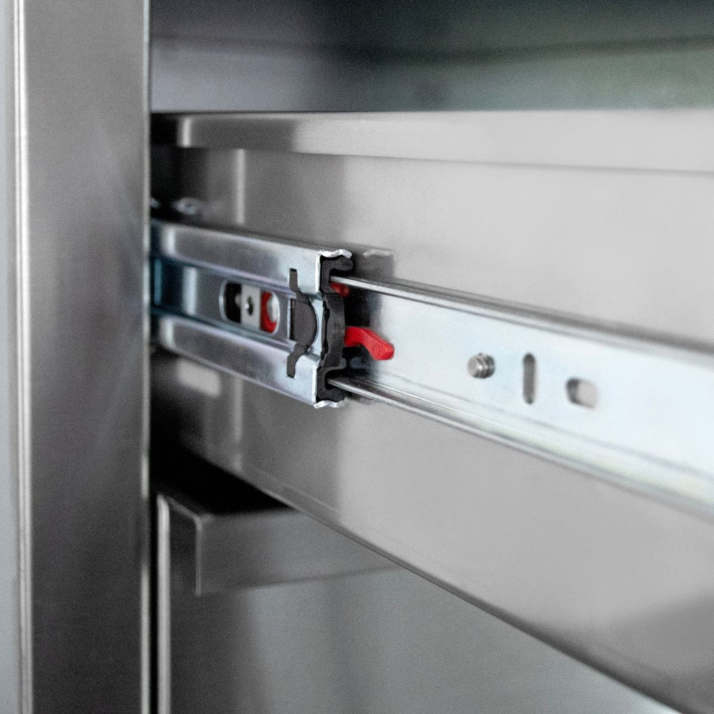 Close-up of a metal drawer slide mechanism with a small red adjustment knob inside a brushed stainless steel cabinet or drawer unit.