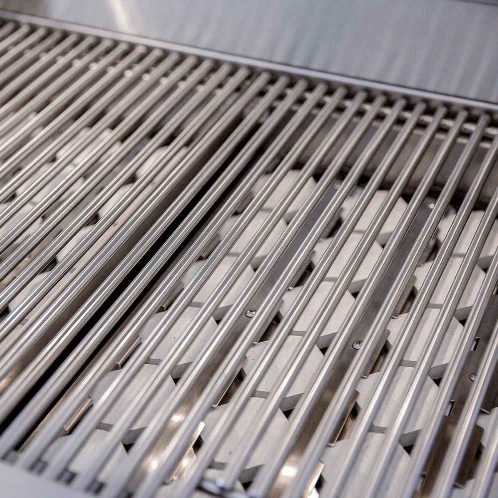 Close-up of stainless steel grill grates with parallel metal bars over a cooking surface.