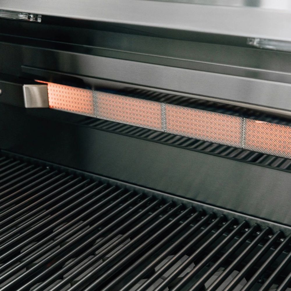 Close-up of a black grill with a glowing orange heat element and dark metal grates.