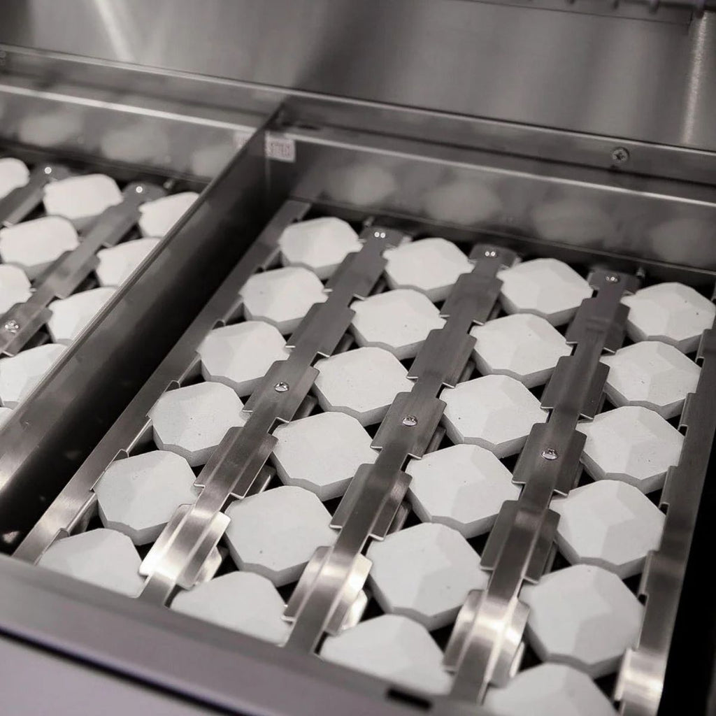 Metallic grill with hexagonal grates and ceramic briquettes inside