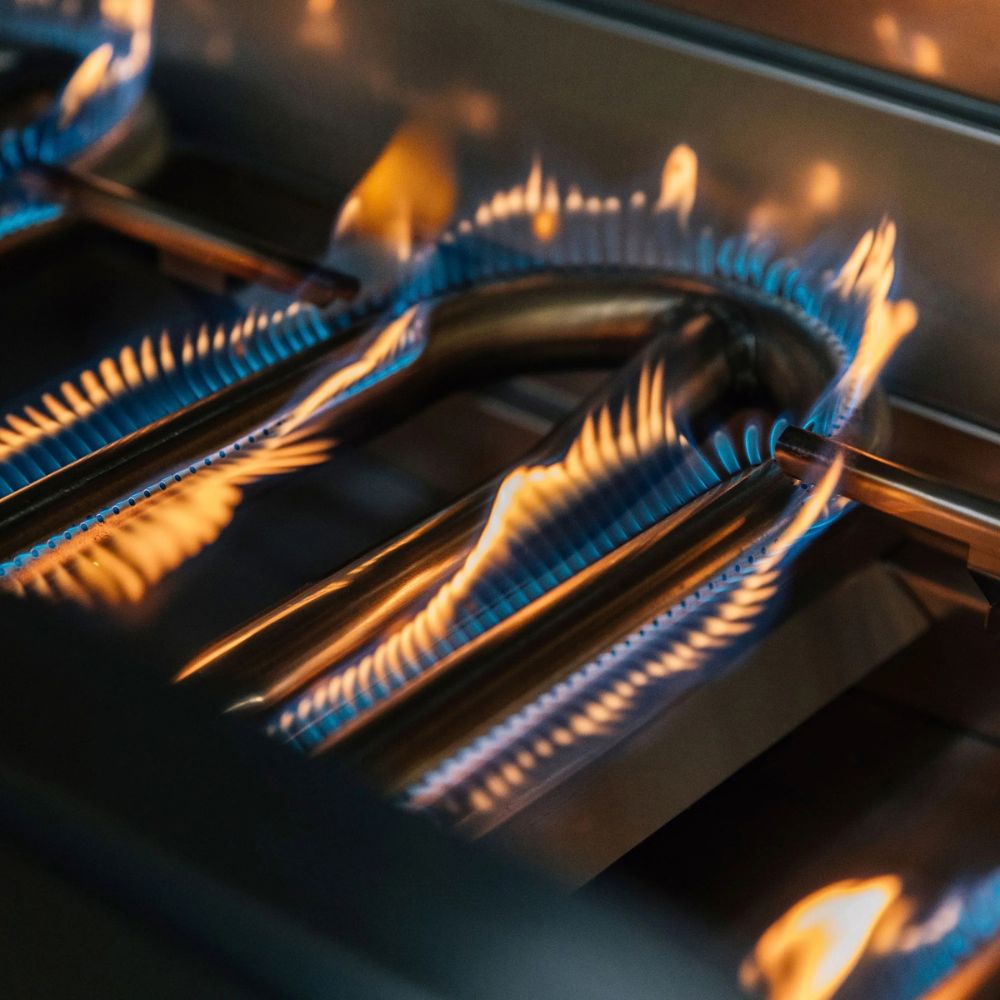 Close-up of gas stove burners with blue flames