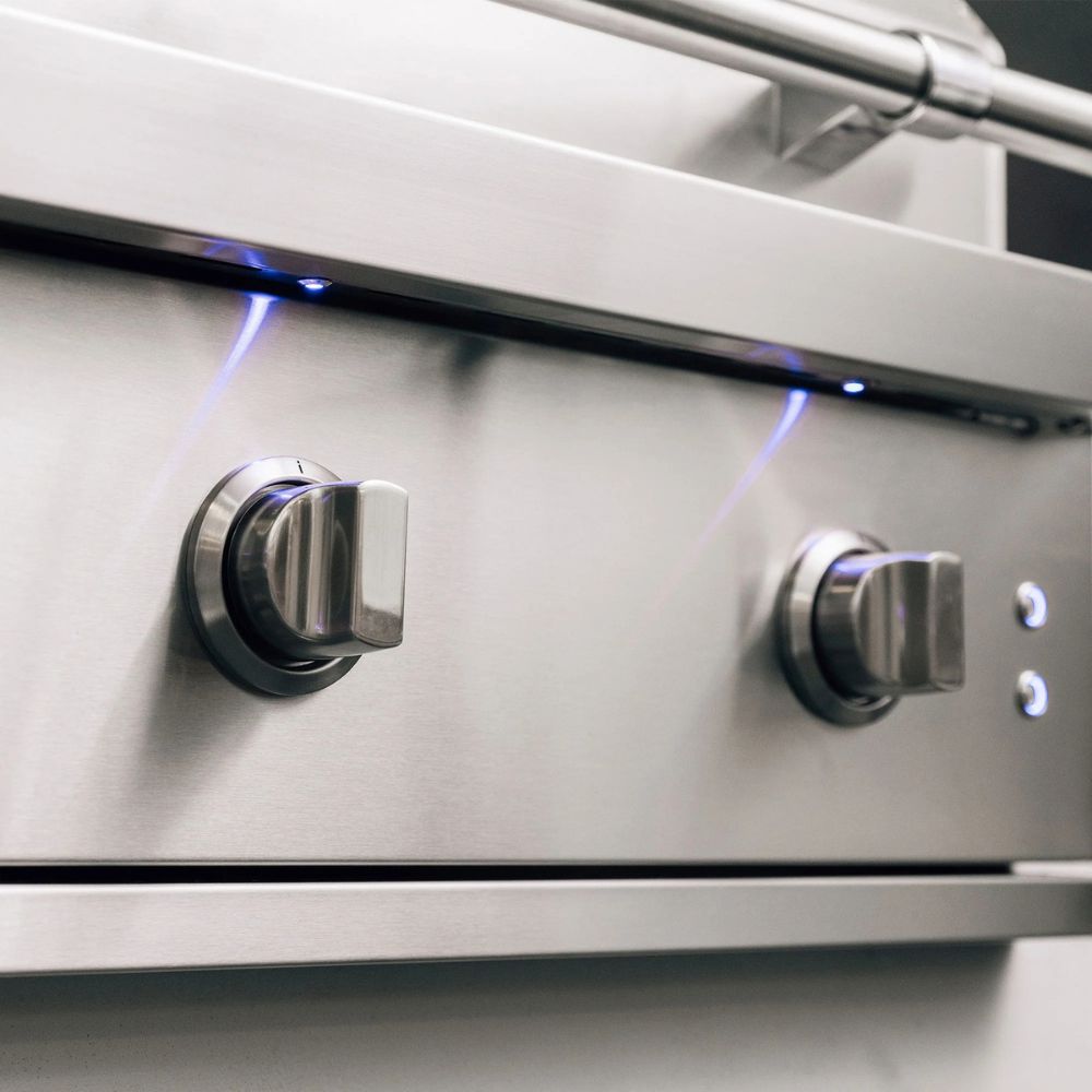Close-up of a stainless steel gas grill with two control knobs.