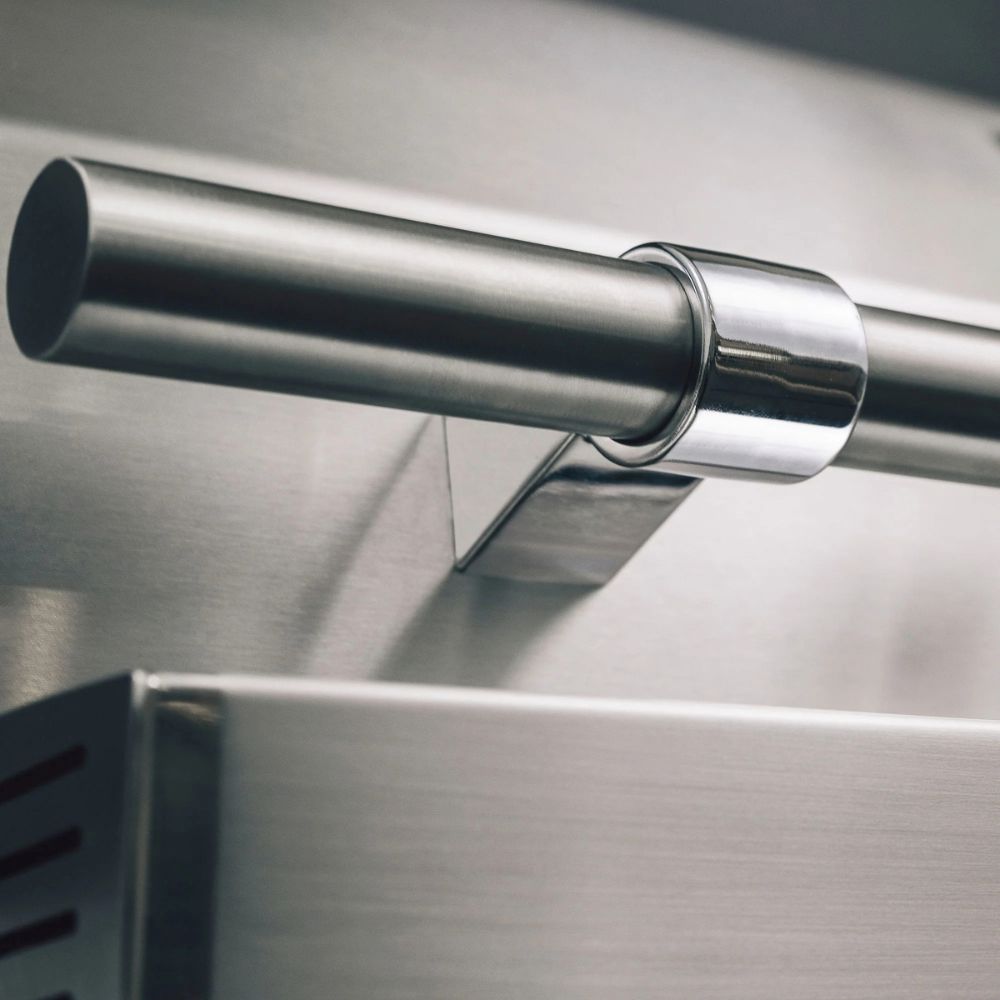 Close-up of a metallic curtain rod on a kitchen cabinet.