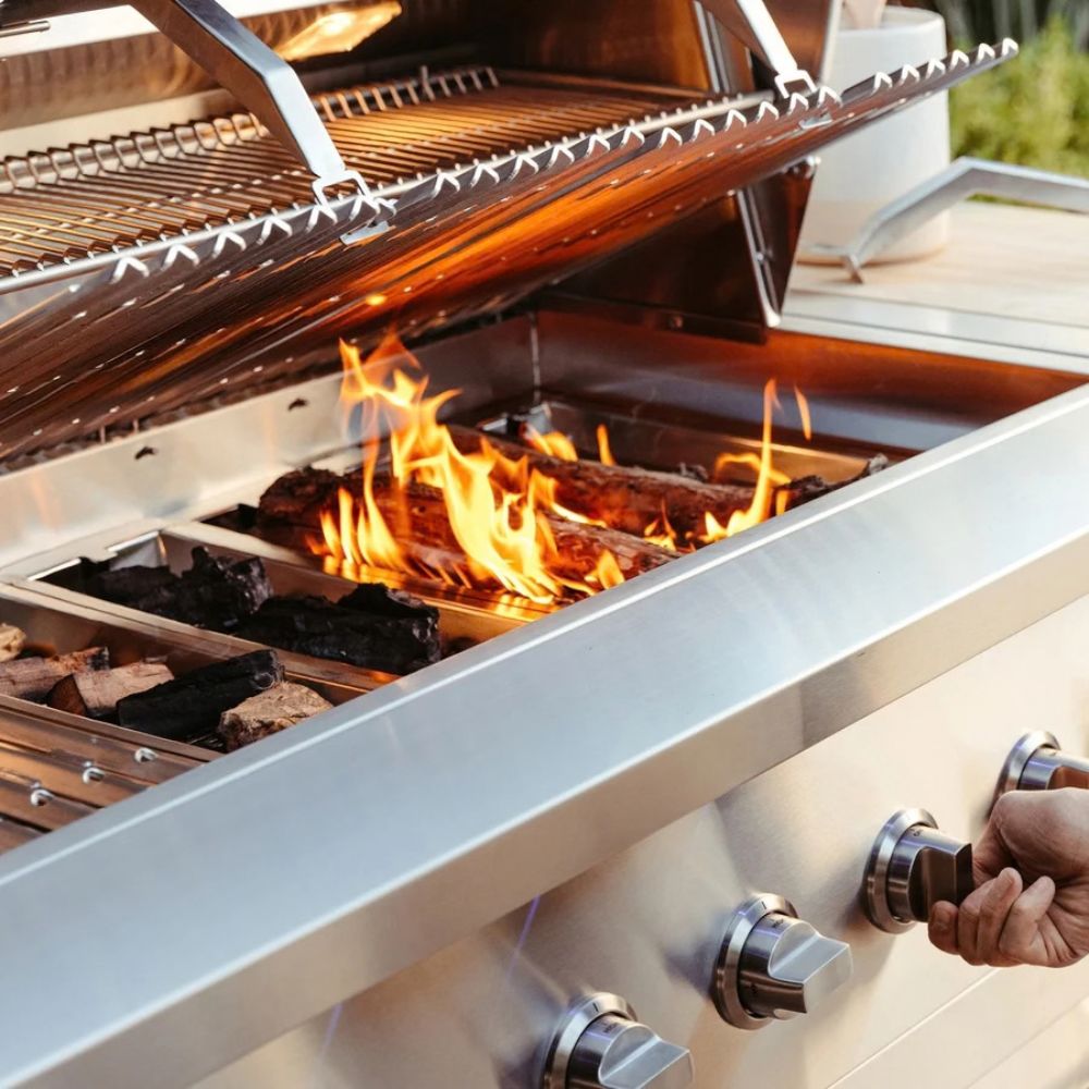 Outdoor grill with flames and food cooking on a sunny day