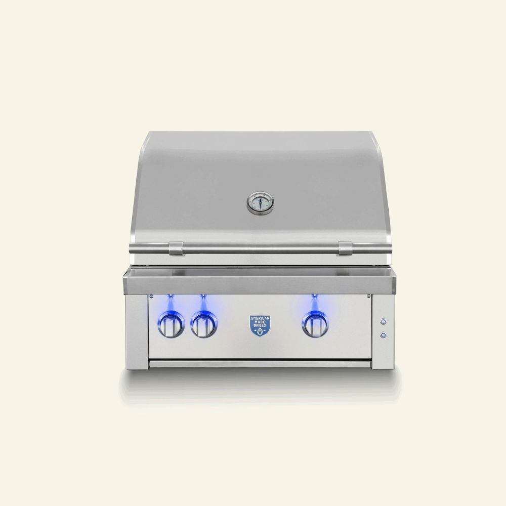 A stainless steel built-in gas grill with a closed lid, three control knobs, blue LED lighting accents, and a small blue logo badge on the front, shown against a solid light beige background.