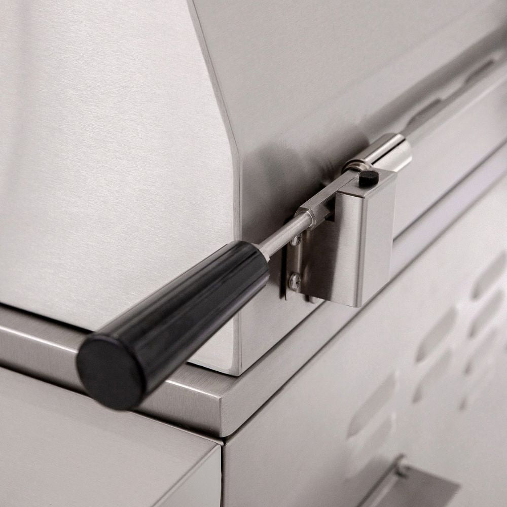 Close-up of a stainless steel outdoor grill with a black-handled latch mechanism.