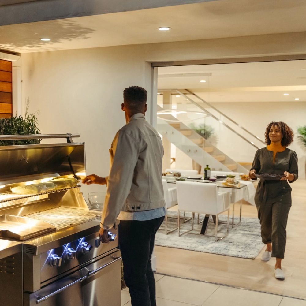 Two people in a modern kitchen with an open oven.