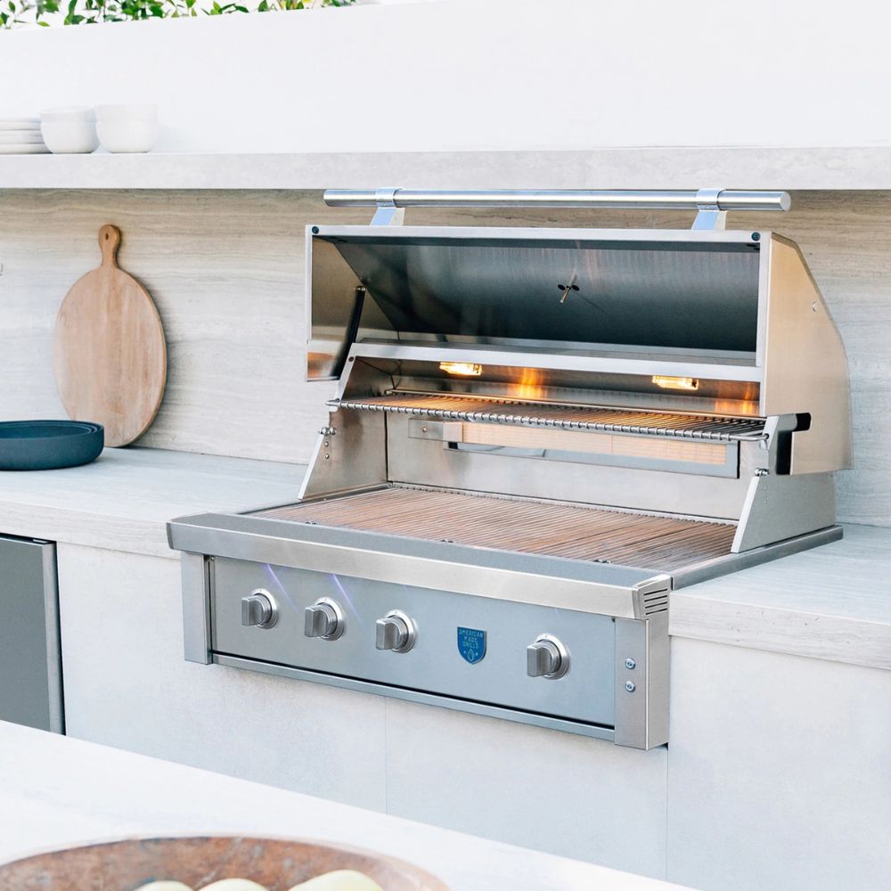 Stainless steel grill on a kitchen counter with wooden cutting board and bowls in the background