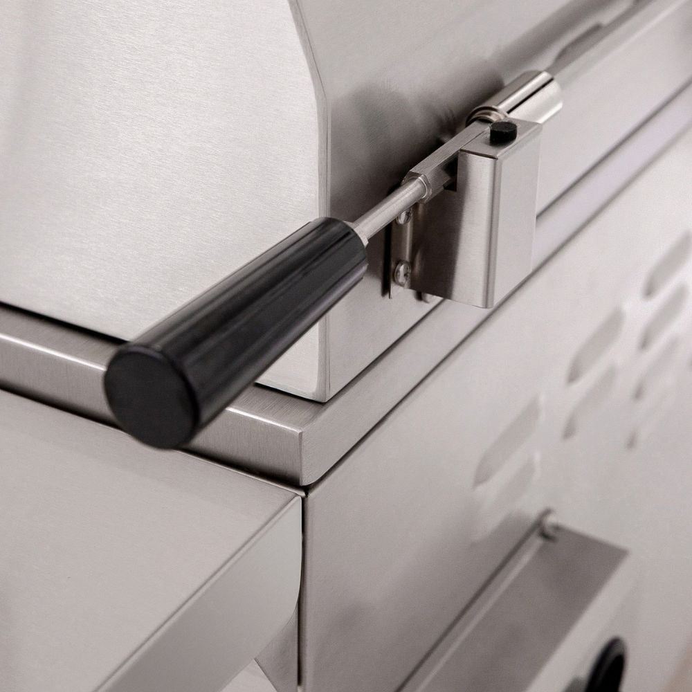 Close-up of a stainless steel outdoor grill with a black handle and metal latch mechanism.