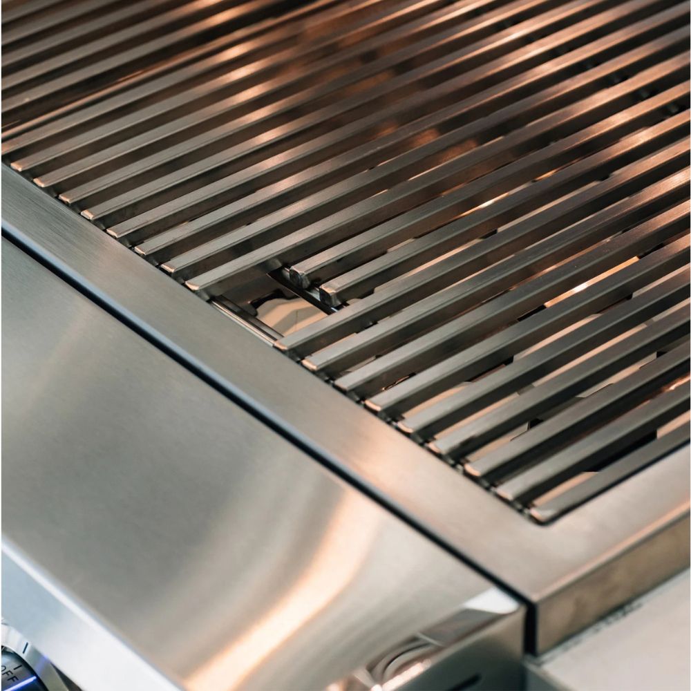 Close-up of a stainless steel outdoor grill showing the metal grate and brushed metal body.