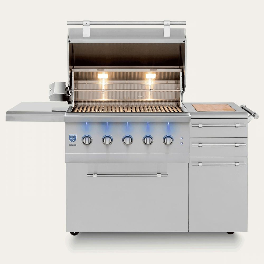 A stainless steel outdoor gas grill with an open lid, side table, control knobs, drawer, and side handle, shown on a clean light gray background.