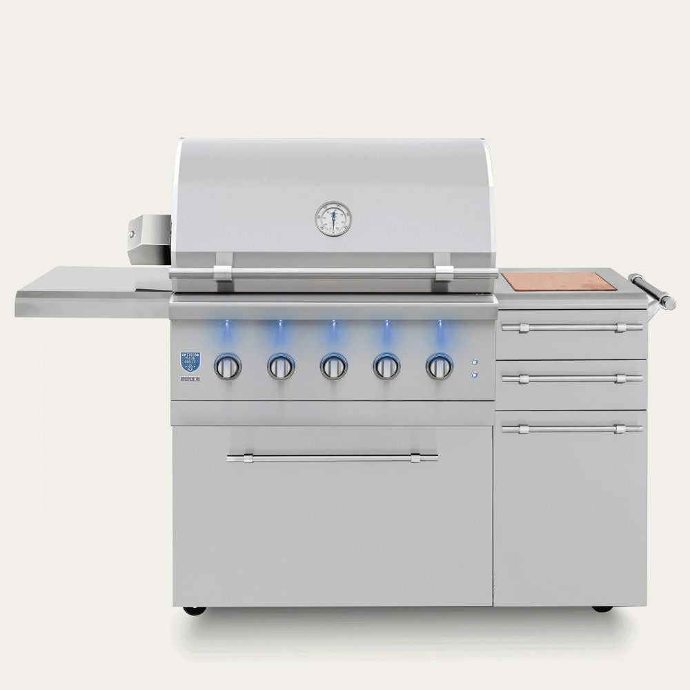 A stainless steel outdoor kitchen island grill with a lid, five front burners with blue flame indicators, a side deck shelf, three drawers, and a wood-grain control panel on a light gray background.