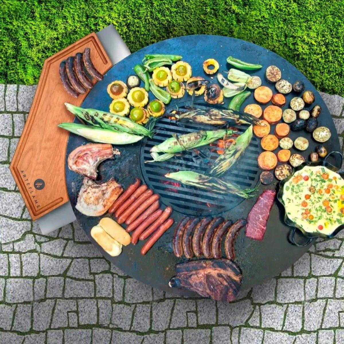 Outdoor grill with various foods on a stone surface and grass background