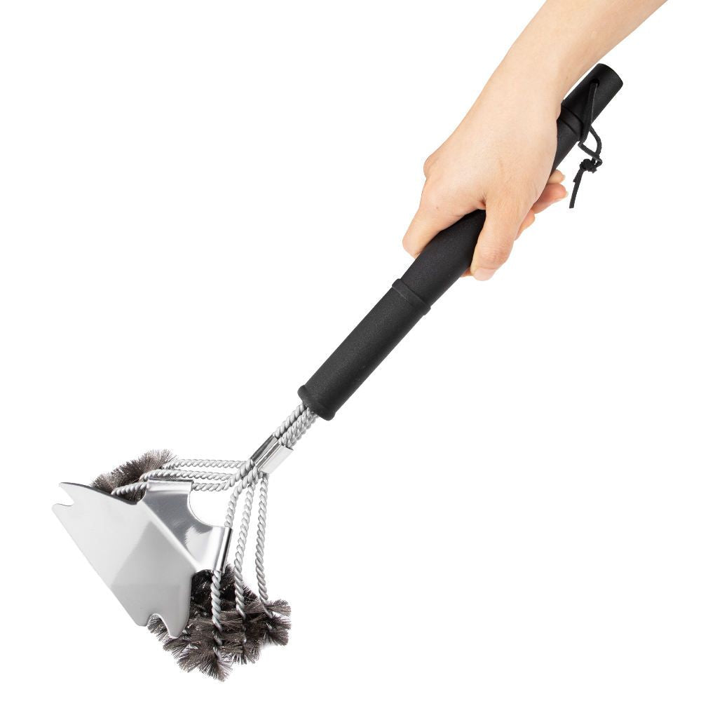 Hand holding a grill cleaning brush with a white background